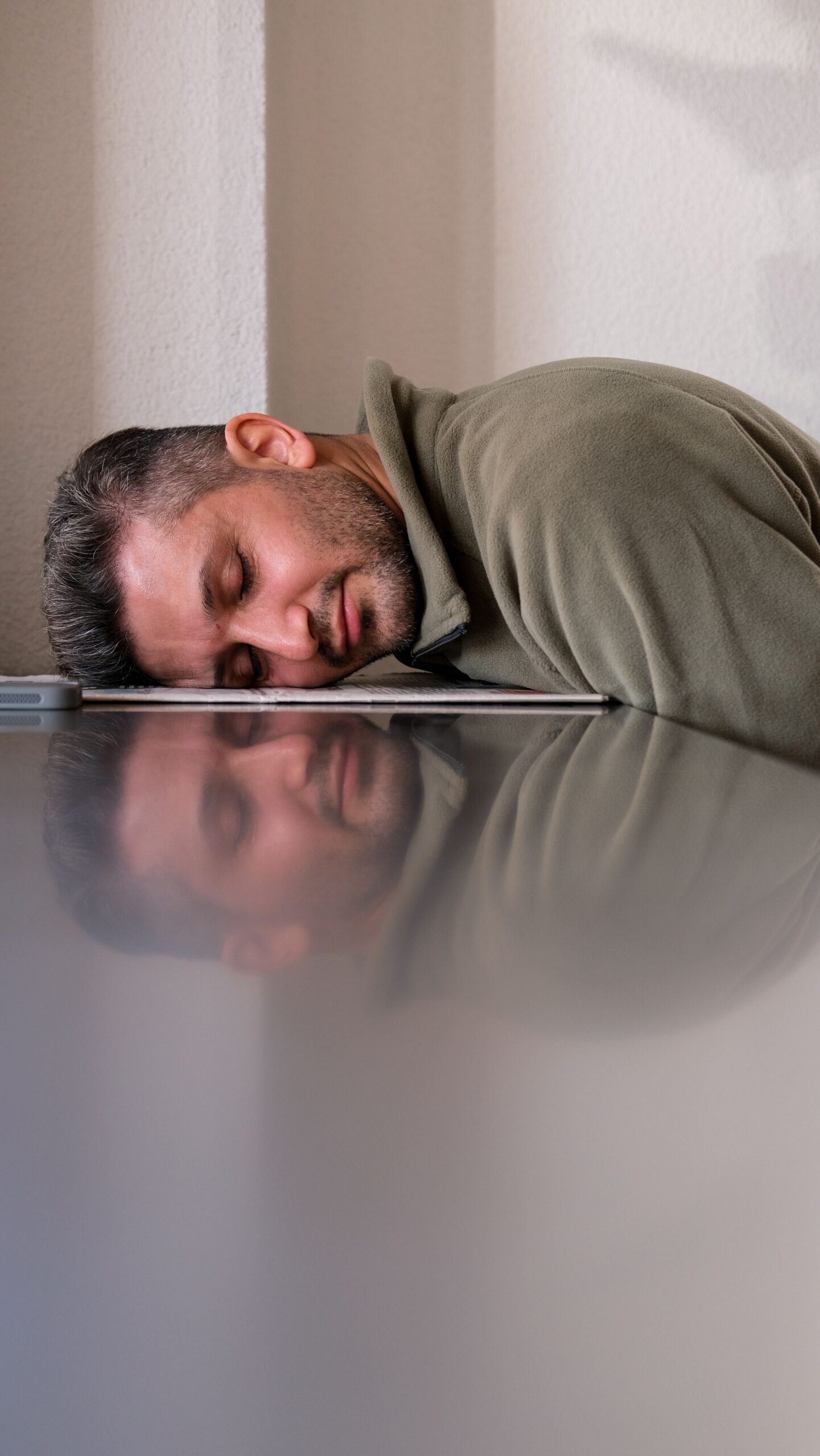 Homme épuisé, tête posée sur un ordinateur portable au bureau